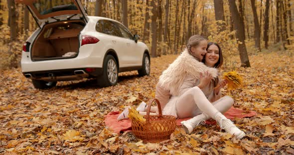 Little Daughter Hugging Mother in Autumn Forest