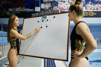 s and principles of swimming to girl in swimsuit while both looking at whiteboard