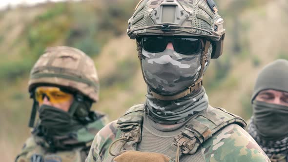 Closeup Portrait of a Military Soldier with Camouflage and Balaclava on His Face and Black Glasses