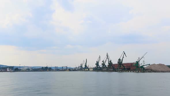 Huge industrial cranes at sea port, cargo transportation, shipbuilding, business