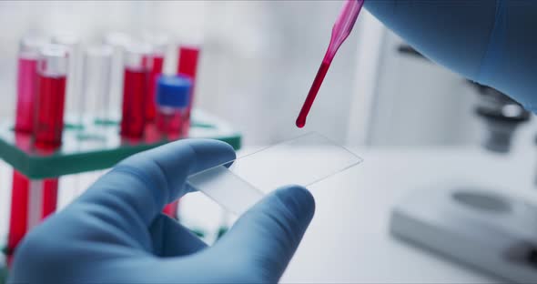 Close- Up of Scientist Studying Sample Under Microscope i alt