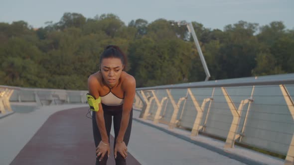 Tired Female Runner Catching Her Breath After Jog alt