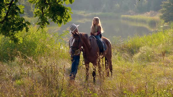 Cowboy and His Daughter on Horseback