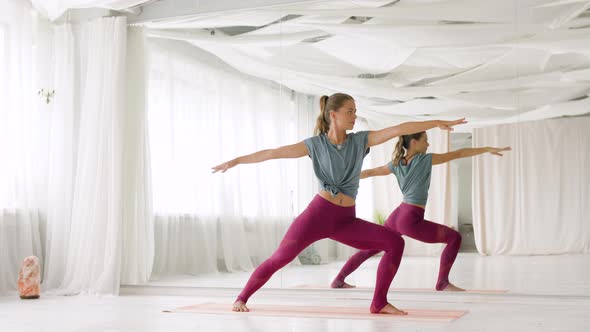 Woman Doing Yoga Warrior Pose at Studio 
