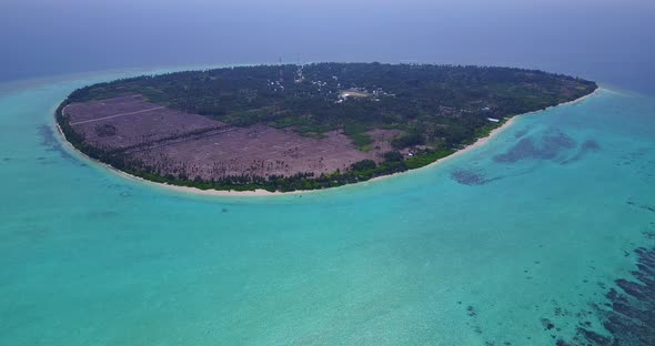 Wide fly over island view of a white sandy paradise beach and aqua turquoise water background in hi 