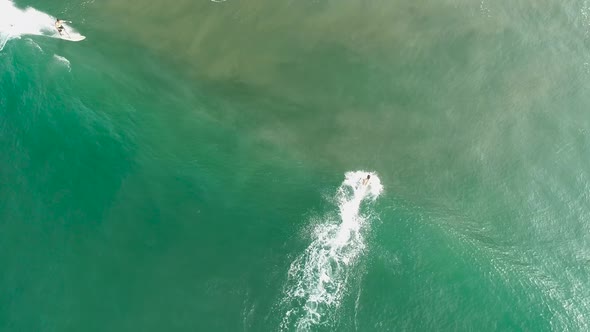 Surfers On Boards Trying To Catch A Wave