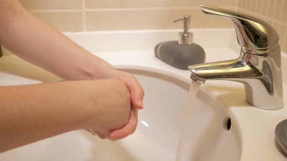 Woman Is Carefully Washing Her Hands with Liquid Soap in Sink, Hands Closeup.