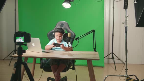 Little Boy Playing Video Game With Mobile Phone Then Celebrating While Live Stream On Green Screen