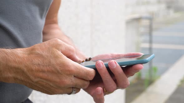 Slow motion shot of senior man typing on smartphone