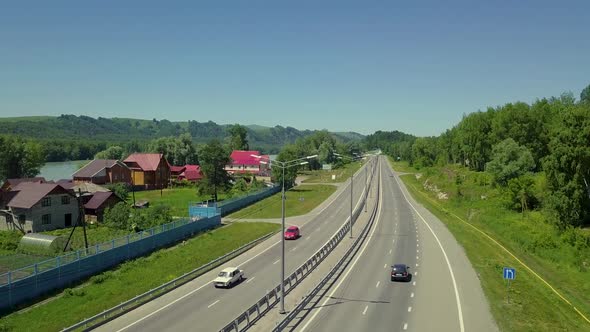 Aerial: Flying Over the Highway. View of the Mountain Turquoise River, Also Visible Tourist City