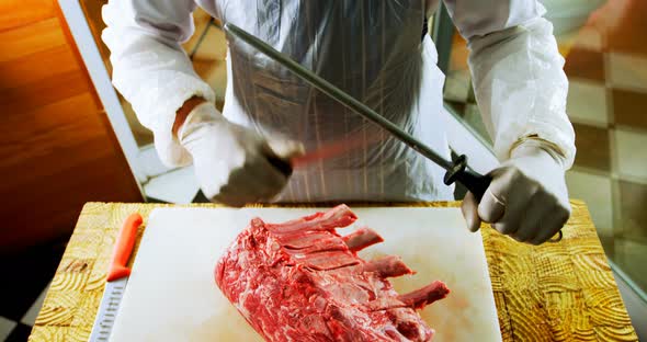 Butcher sharping knife in shop 