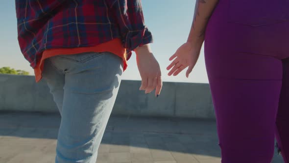 Back View of Loving Multiracial Lesbian Couple Holding Hands at Sunrise