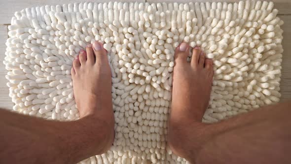 Male Legs on Fluffy Carpet at Bathroom