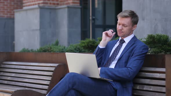 Pensive Businessman Thinking and Working on Laptop