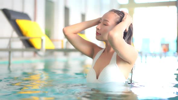 Young asian woman enjoy around outdoor swimming pool for leisure