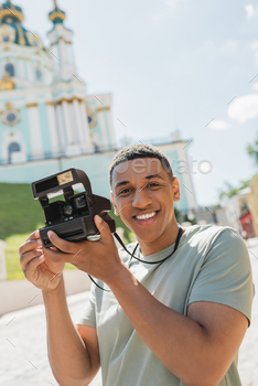 era smiling near blurred St Andrews Church in Kyiv