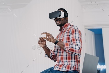 Modern african american man in virtual reality glasses enjoying virtual tour in augmented cyberspace