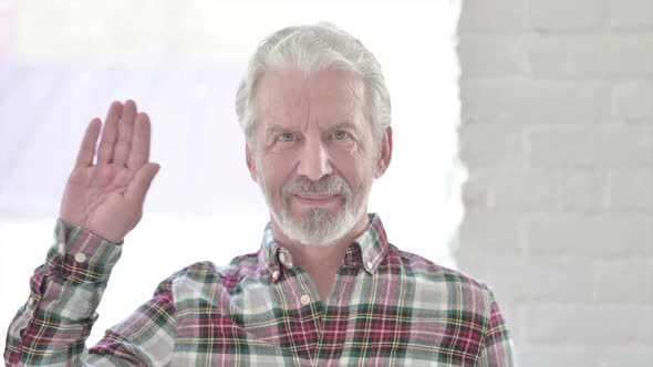 Portrait of Casual Old Man Waving at the Camera