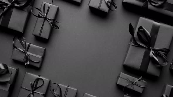 Arranged Gifts Boxes Wrapped in Black Paper with Black Ribbon on Black Background. Christmas Concept