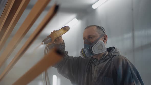 Man Painting Metal in Factory