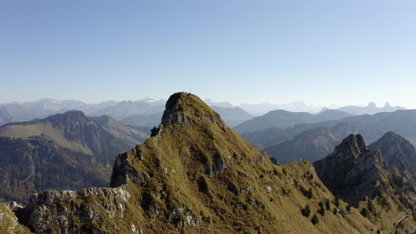 Overflying summit with hikers on top. The Alps in the background and autumn colors"La Cape au Moine