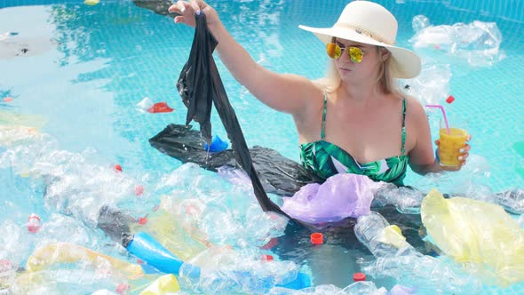 Concept of Pollution of the Planet. Young Shocked Woman Swims Among the Trash