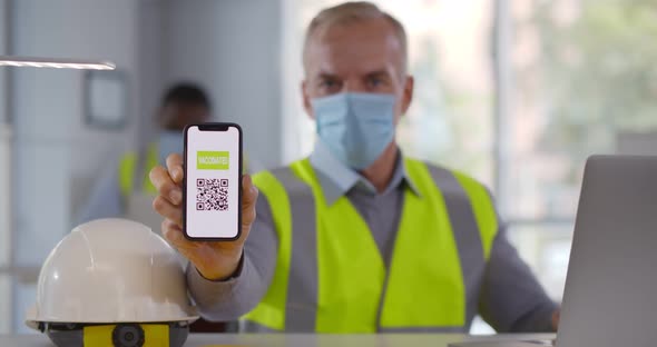 Mature Foreman in Safety Mask Showing Vaccinate Qrcode on Cellphone at Camera