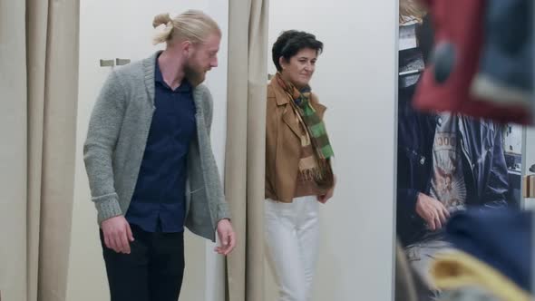 Confident Caucasian Man and Woman Opening Curtains in Clothing Shop Dressing Room and Posing in New