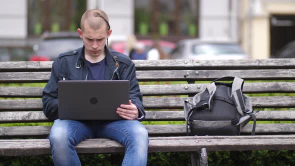 Student Working Remotely on Laptop in City Park