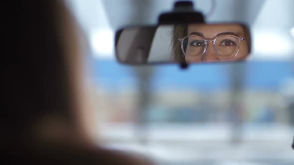 Reflection of Female Eyes in the Front Mirror of the Car