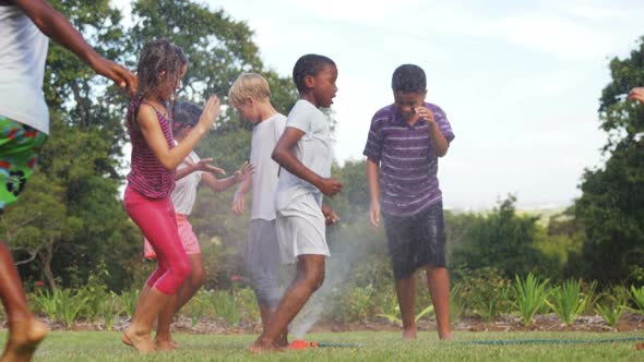 Kids playing with garden sprinkler