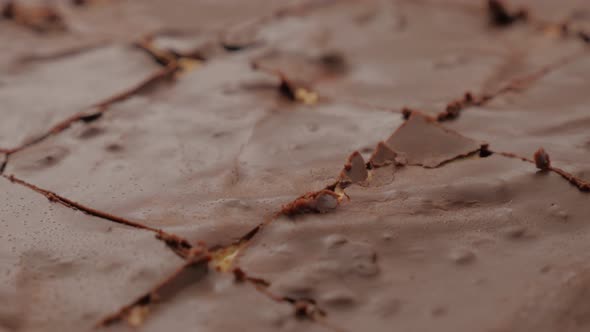 Glazed chocolate cake divided on smaller pieces slow tilt 4K 2160p UltraHD footage - Slow tilting ov