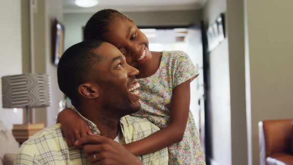 Daughter embracing her father in living room 4k