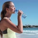 Young woman drinking water on beach - VideoHive Item for Sale