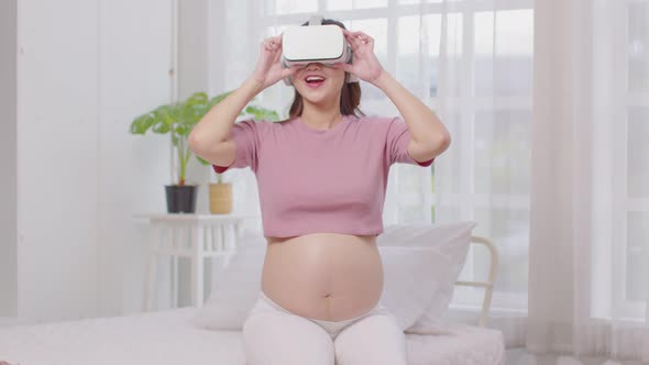 Happy Pregnant woman using virtual reality glasses for practice tutorial to take care