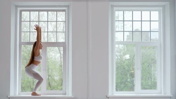 Calm Brunette Woman Doing Yoga on Window at Home