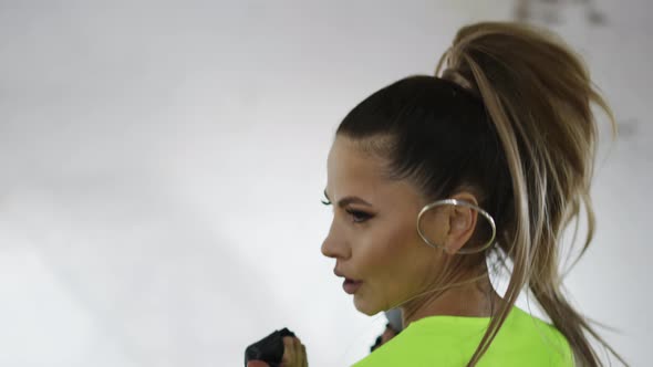 Woman Training with Weights Performing Kicks in Studio