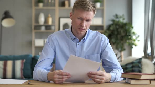 Businessman Reading Documents at Work Contract