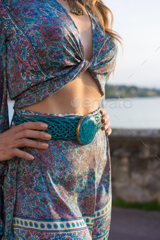 Model posing with a blue belt with a gem