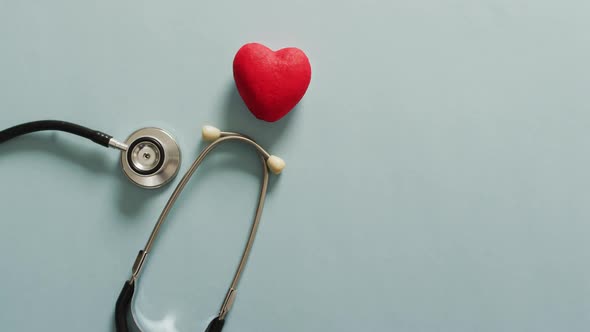 Video of close up of stethoscope with heart on blue background