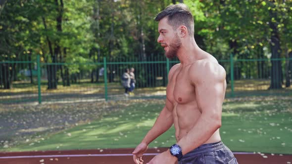 Muscular man doing his workout outdoors. 