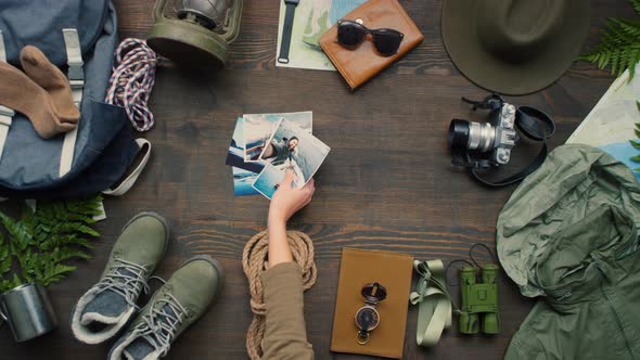 Top View of Female Hand Putting Photos on Table