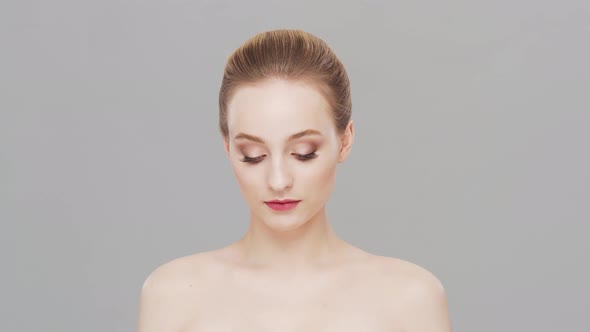 Studio portrait of young, beautiful and natural woman over grey background.