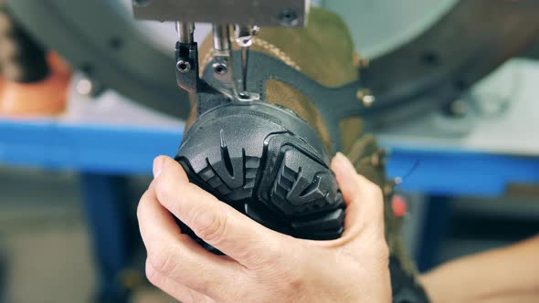 Shoemaking Industry Concept. Factory Worker Attaching Sole To a Shoe Using a Machine