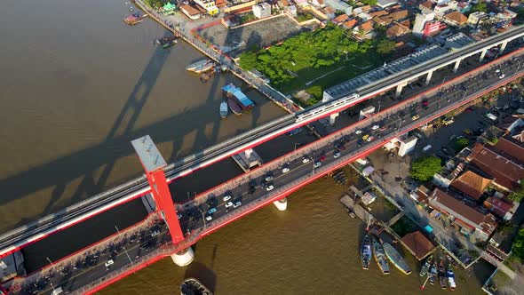 Massive traffic of motorbikes and vehicles over Ampera bridge, aerial drone view