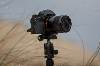 Closeup shot of a mirrorless camera on a tripod at the beach