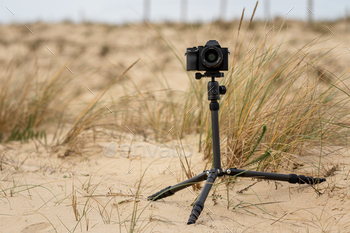 Closeup shot of a mirrorless camera on a tripod at the beach