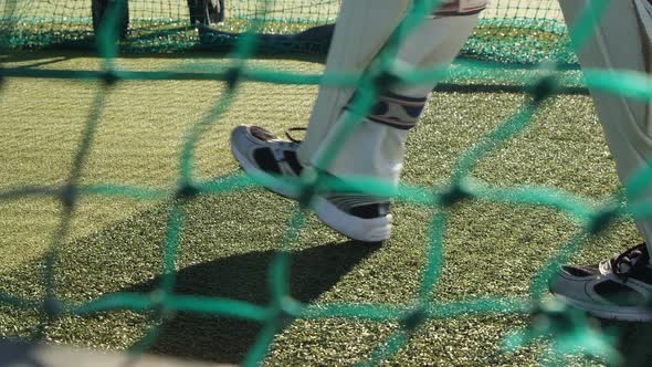 Cricket player walking on the pitch during a practice session