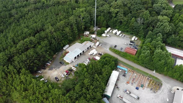 Aerial tracking of an auto shop scrap yard in the forest.