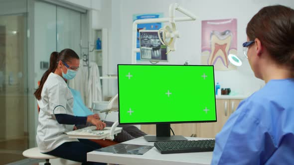 Stomatologist Nurse Looking at Green Screen Tablet